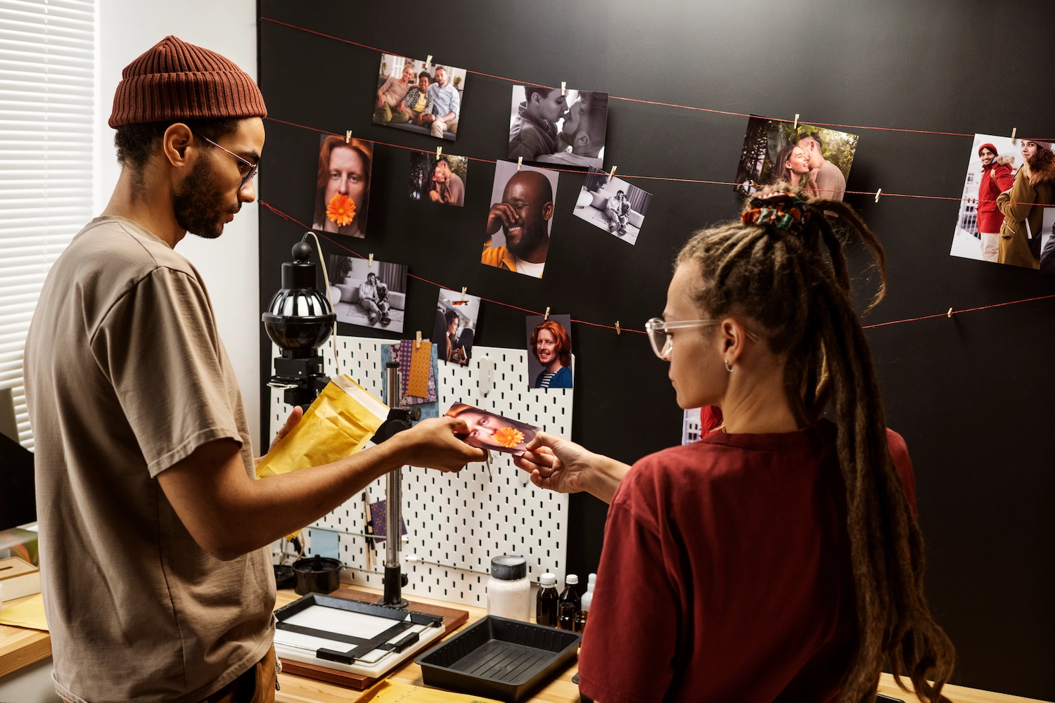 Collection of printed photographs arranged on a workspace showing diverse portrait and lifestyle imagery